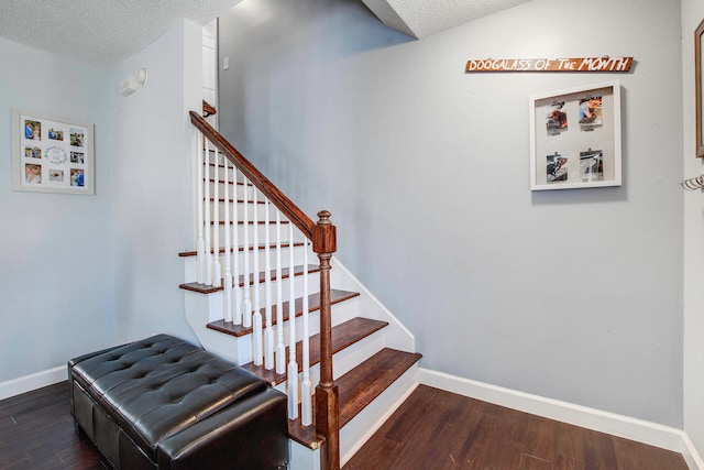 stairway featuring dark hardwood / wood-style floors and a textured ceiling