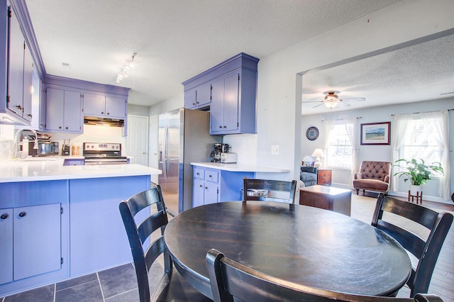 tiled dining area with sink, track lighting, ceiling fan, and a textured ceiling