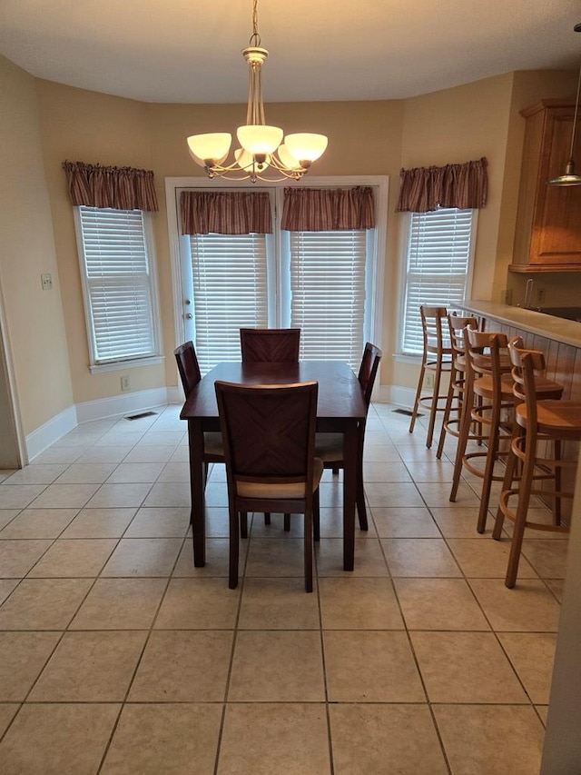 dining area with light tile patterned flooring and a chandelier