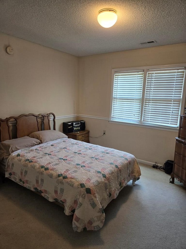 bedroom with carpet floors and a textured ceiling