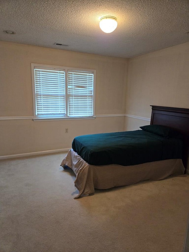 carpeted bedroom featuring a textured ceiling