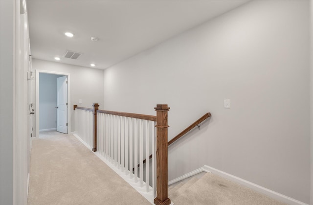 corridor featuring an upstairs landing, visible vents, light colored carpet, and recessed lighting