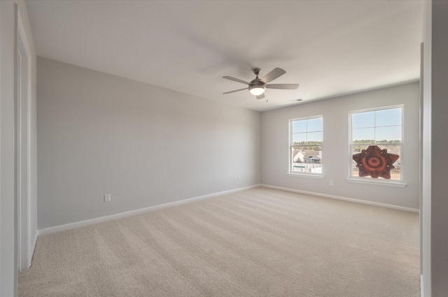 empty room with visible vents, baseboards, light carpet, and a ceiling fan