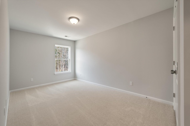 empty room with carpet flooring, visible vents, and baseboards