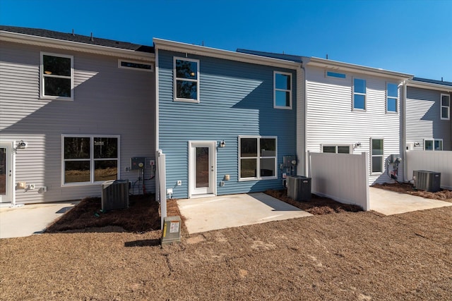 rear view of property with fence, central AC unit, and a patio area