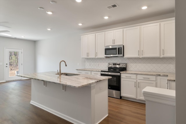 kitchen featuring a sink, stainless steel appliances, white cabinets, and a center island with sink