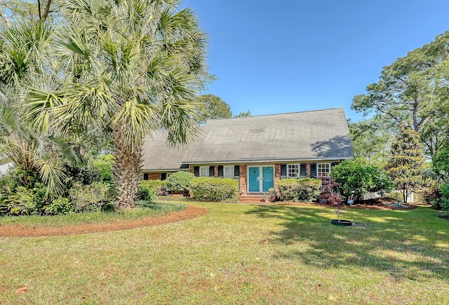 cape cod house with a front yard, entry steps, and brick siding