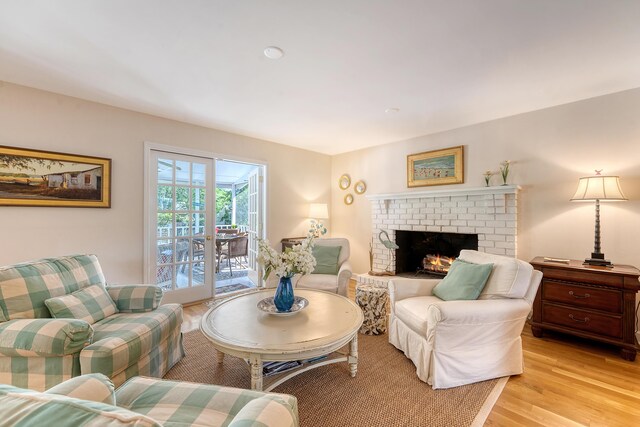 living area with light wood-type flooring and a brick fireplace