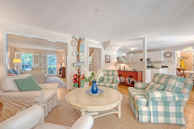 living room featuring light wood-style flooring and stairway