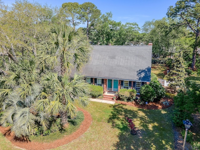 view of front of home with a front yard and a chimney