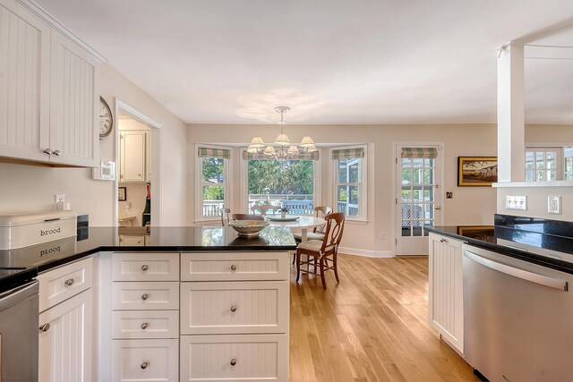 kitchen featuring dishwasher, a peninsula, light wood-type flooring, a chandelier, and white cabinets