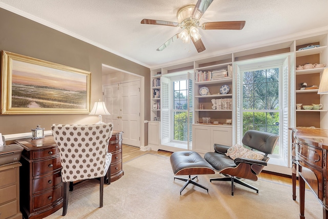 office space with ornamental molding, a ceiling fan, light wood-style floors, a textured ceiling, and built in features