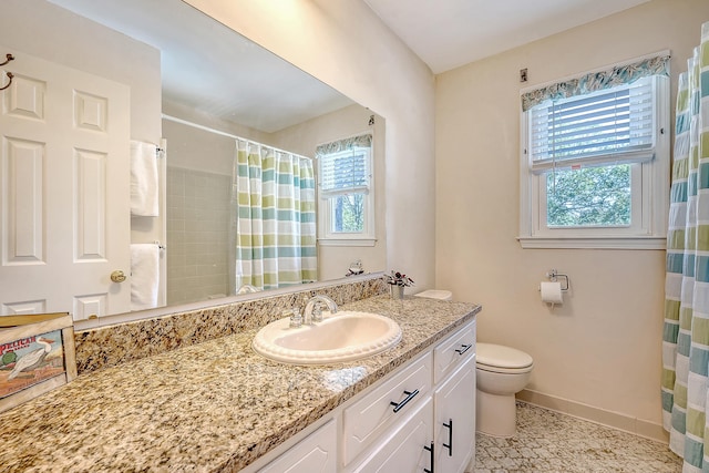 full bath featuring healthy amount of natural light, baseboards, toilet, and vanity