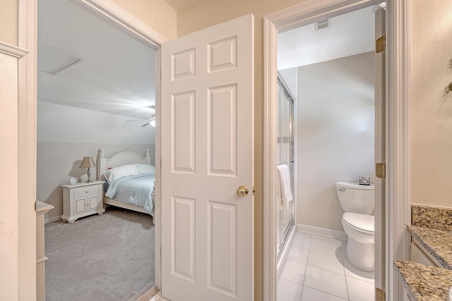 ensuite bathroom featuring a shower stall, toilet, vanity, and baseboards