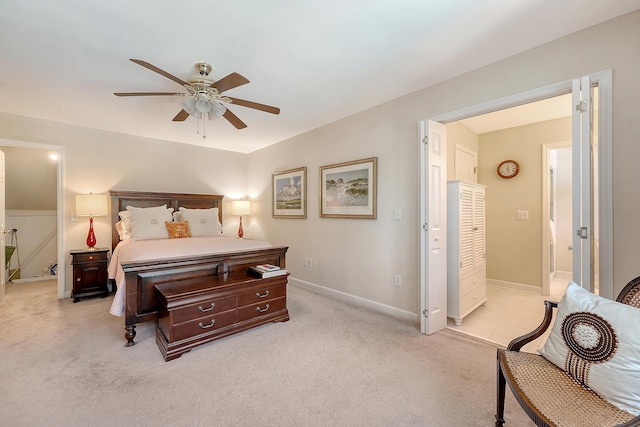 bedroom featuring light colored carpet, a ceiling fan, and baseboards