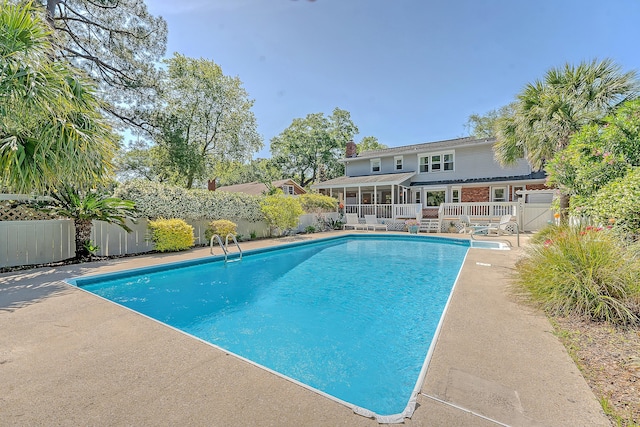 view of swimming pool featuring a sunroom and a fenced backyard