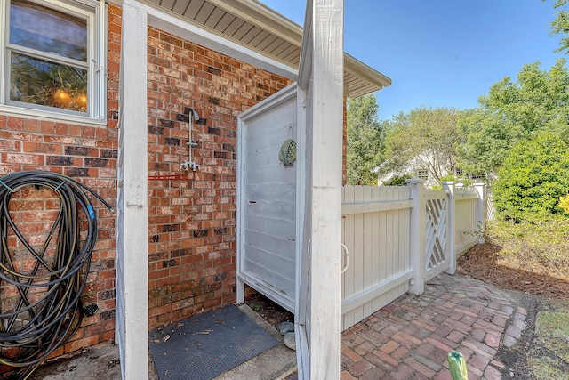 property entrance with brick siding and fence