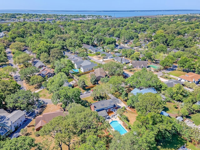 drone / aerial view of a pool and a nearby body of water