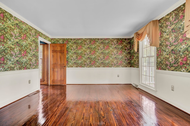 spare room featuring wood-type flooring, ornamental molding, and a wealth of natural light