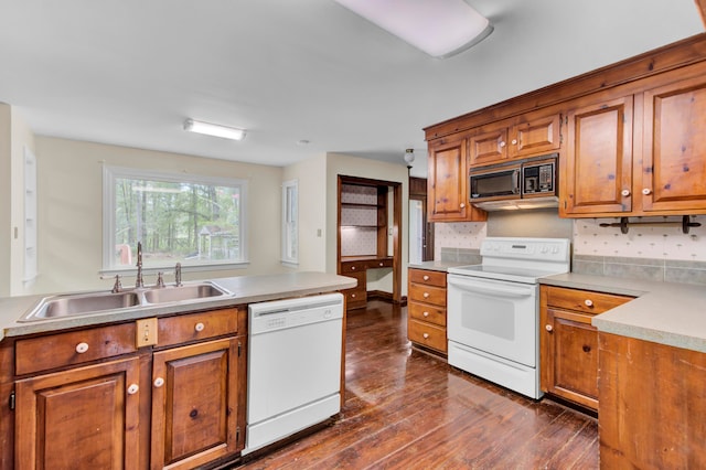 kitchen featuring tasteful backsplash, white appliances, sink, and dark hardwood / wood-style flooring