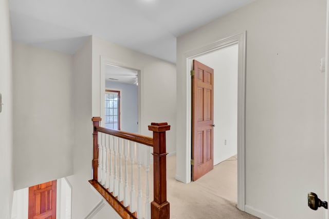 hallway featuring light colored carpet