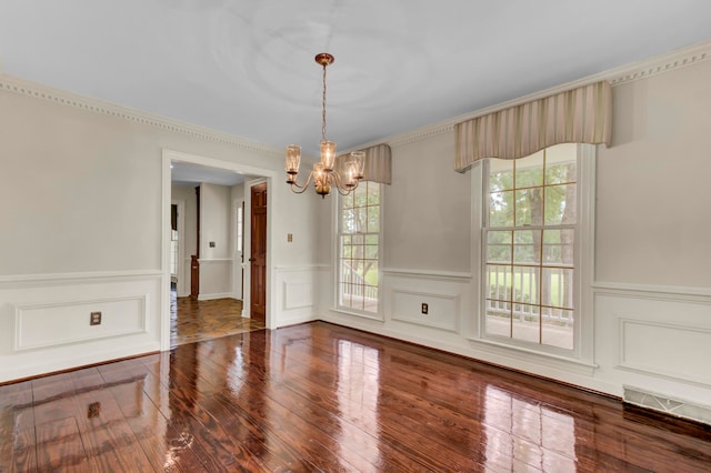 unfurnished dining area with ornamental molding, an inviting chandelier, and tile patterned flooring