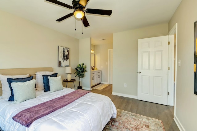 bedroom with ceiling fan, ensuite bath, wood finished floors, and baseboards