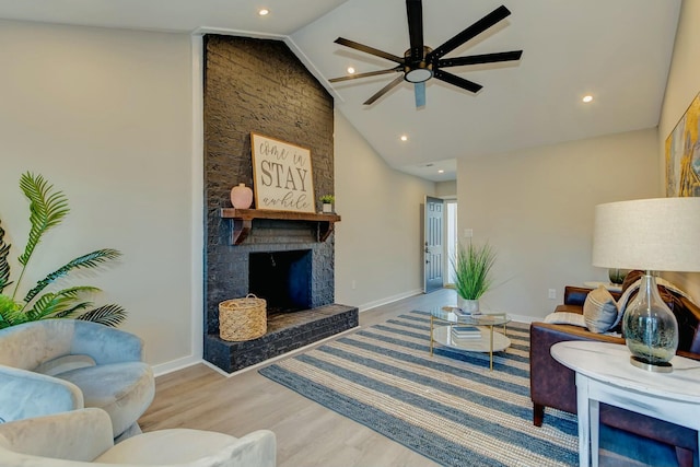 living area featuring ceiling fan, high vaulted ceiling, a large fireplace, wood finished floors, and baseboards