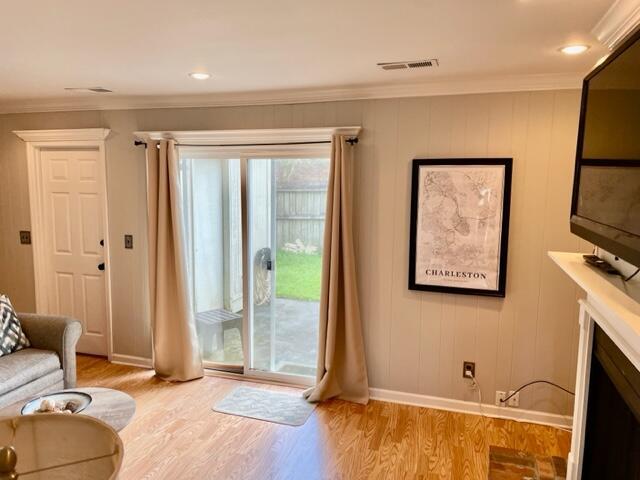 living room featuring light hardwood / wood-style floors and ornamental molding