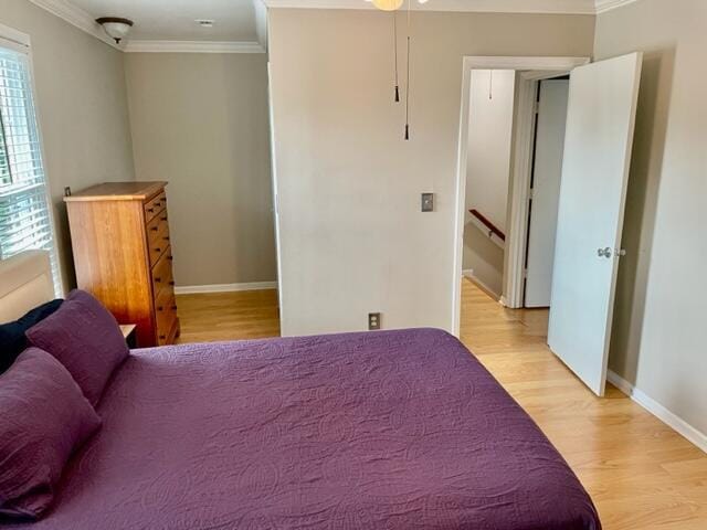 bedroom featuring light hardwood / wood-style flooring, multiple windows, and crown molding