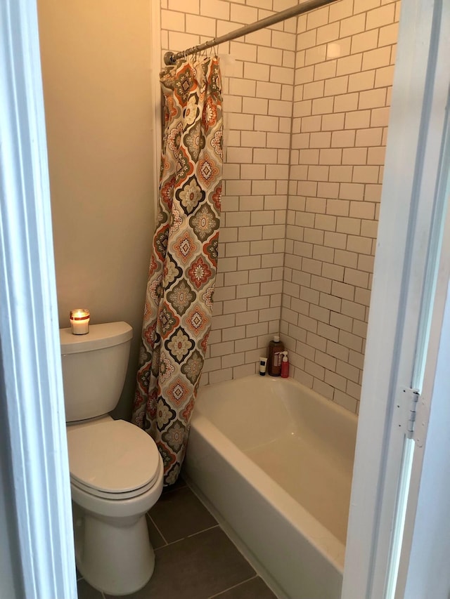 bathroom featuring tile patterned flooring, shower / bath combination with curtain, and toilet