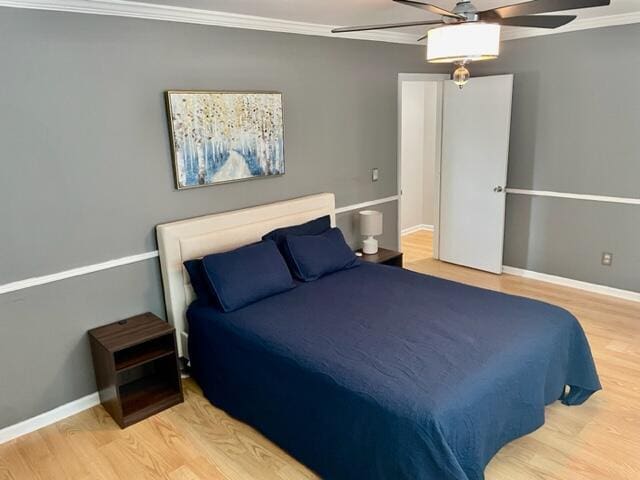 bedroom featuring hardwood / wood-style flooring, ceiling fan, and ornamental molding