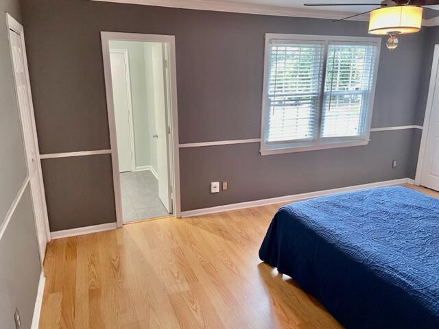 bedroom with light hardwood / wood-style floors and ornamental molding