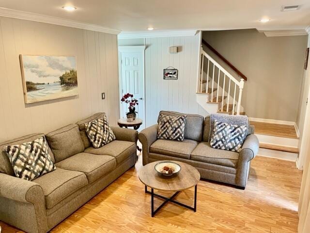 living room featuring crown molding and light hardwood / wood-style flooring