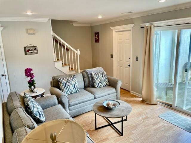 living room with plenty of natural light, ornamental molding, and light hardwood / wood-style flooring