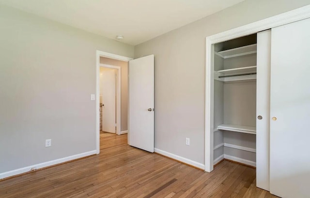 unfurnished bedroom with light hardwood / wood-style flooring and a closet