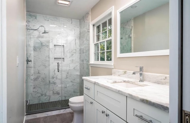 bathroom with vanity, a shower with shower door, and toilet