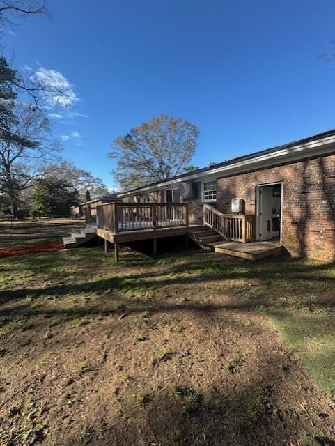 rear view of property with a yard and a wooden deck