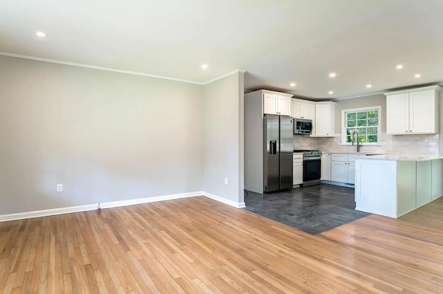 kitchen featuring white cabinets, ornamental molding, stainless steel appliances, and tasteful backsplash