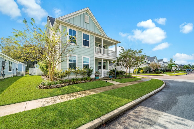 view of front of property featuring a balcony and a front yard