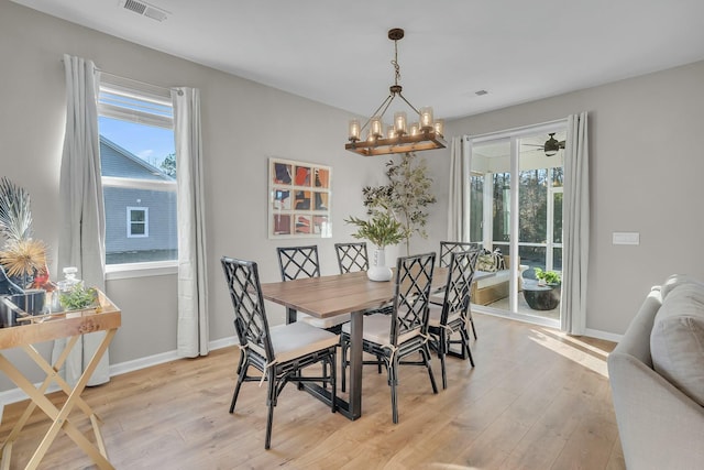 dining space featuring a wealth of natural light, light hardwood / wood-style flooring, and a chandelier