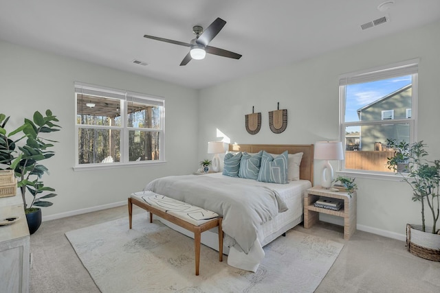 carpeted bedroom with multiple windows and ceiling fan