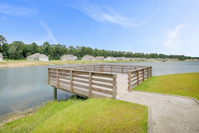 view of dock with a water view and a yard