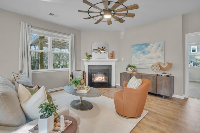 sitting room with ceiling fan and light hardwood / wood-style flooring