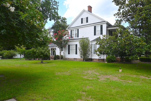 exterior space featuring crawl space, a chimney, and a front yard