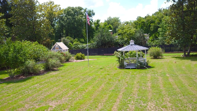 view of yard with a gazebo, fence, and an outbuilding