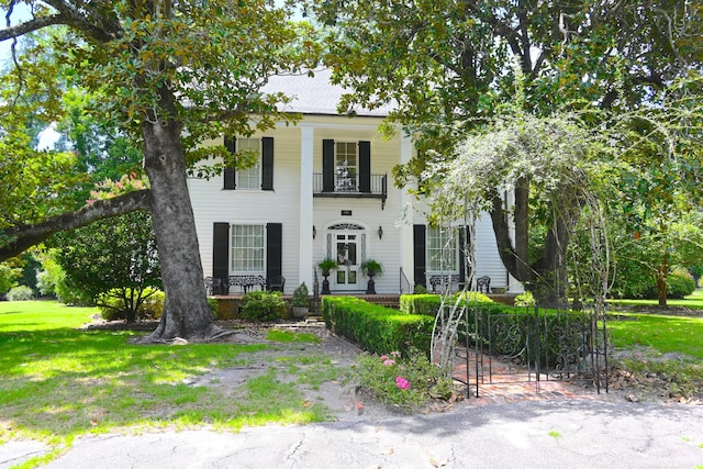 neoclassical / greek revival house with a front lawn and a balcony