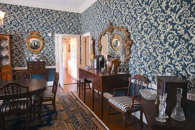 dining room featuring wallpapered walls, crown molding, and wood finished floors