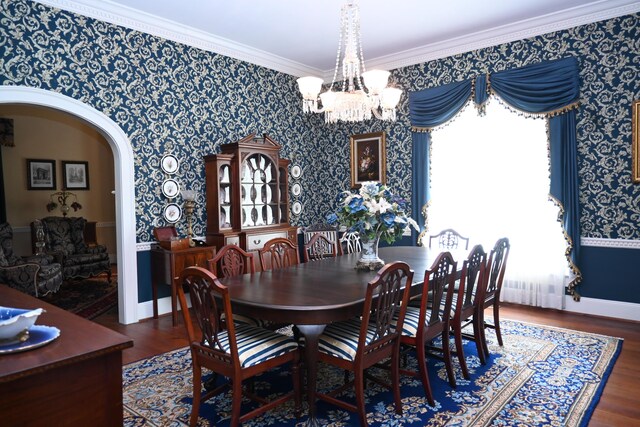 dining area with arched walkways, wallpapered walls, an inviting chandelier, and wood finished floors