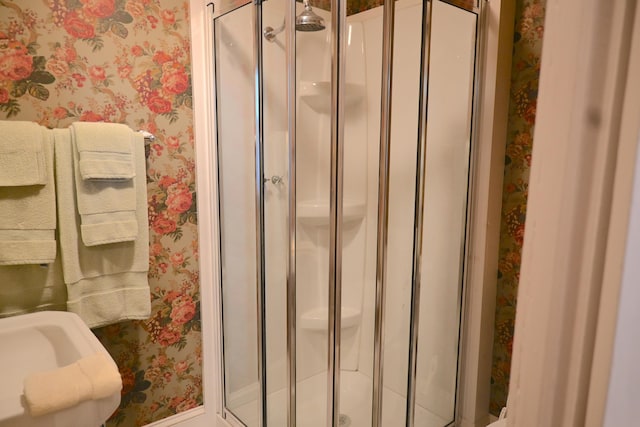 full bathroom with a shower stall and wallpapered walls